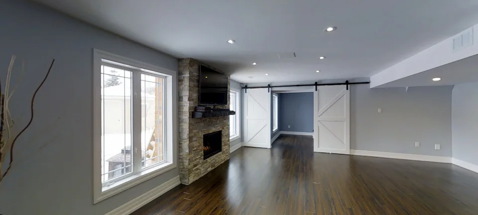 The family room and the custom barn doors, in a finished basement in Aurora by Harmony Basements, captured in 360 degrees