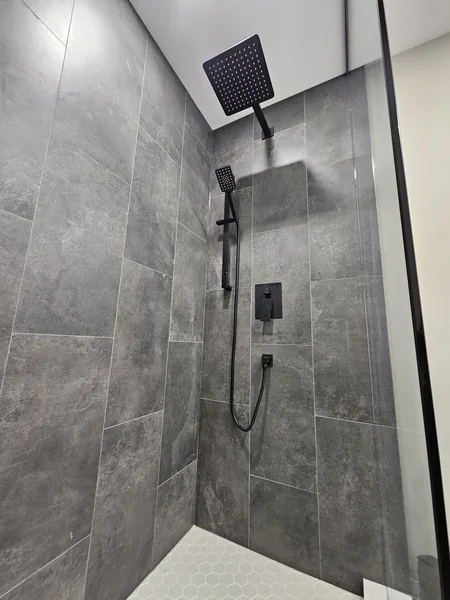 Basement bathroom Ajax: the tiled shower with matte black fixtures — built in East Gwillimbury