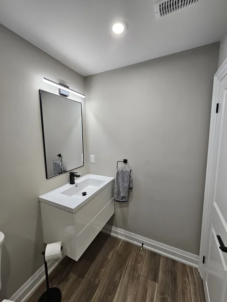 Basement bathroom Stouffville: the floating vanity and its lit mirror — built in East Gwillimbury
