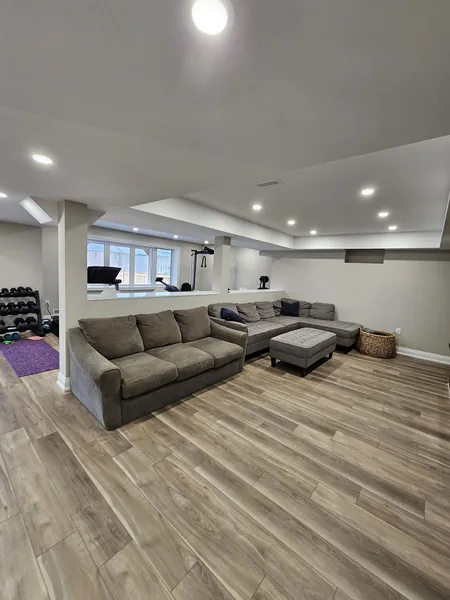 Finished basement Oshawa: the open plan from the gym to the family room — built in East Gwillimbury