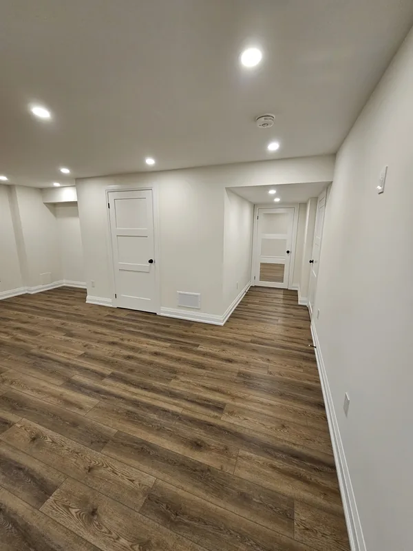 Basement remodeling Milton: the hallway with three-panel shaker doors and new baseboards, by Harmony Basements — built in Hamilton