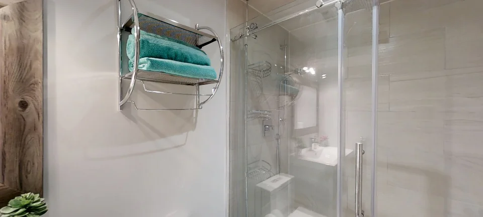 The bathroom: a glass shower and a rustic mirror, in a finished basement in Maple by Harmony Basements, captured in 360 degrees