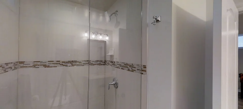 The bathroom: a glass shower with a mosaic band, in a finished basement by Harmony Basements, captured in 360 degrees
