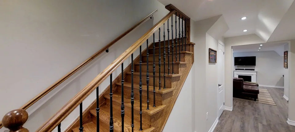 The new open staircase: oak railing and iron pickets, in a finished Harmony basement, captured in 360 degrees