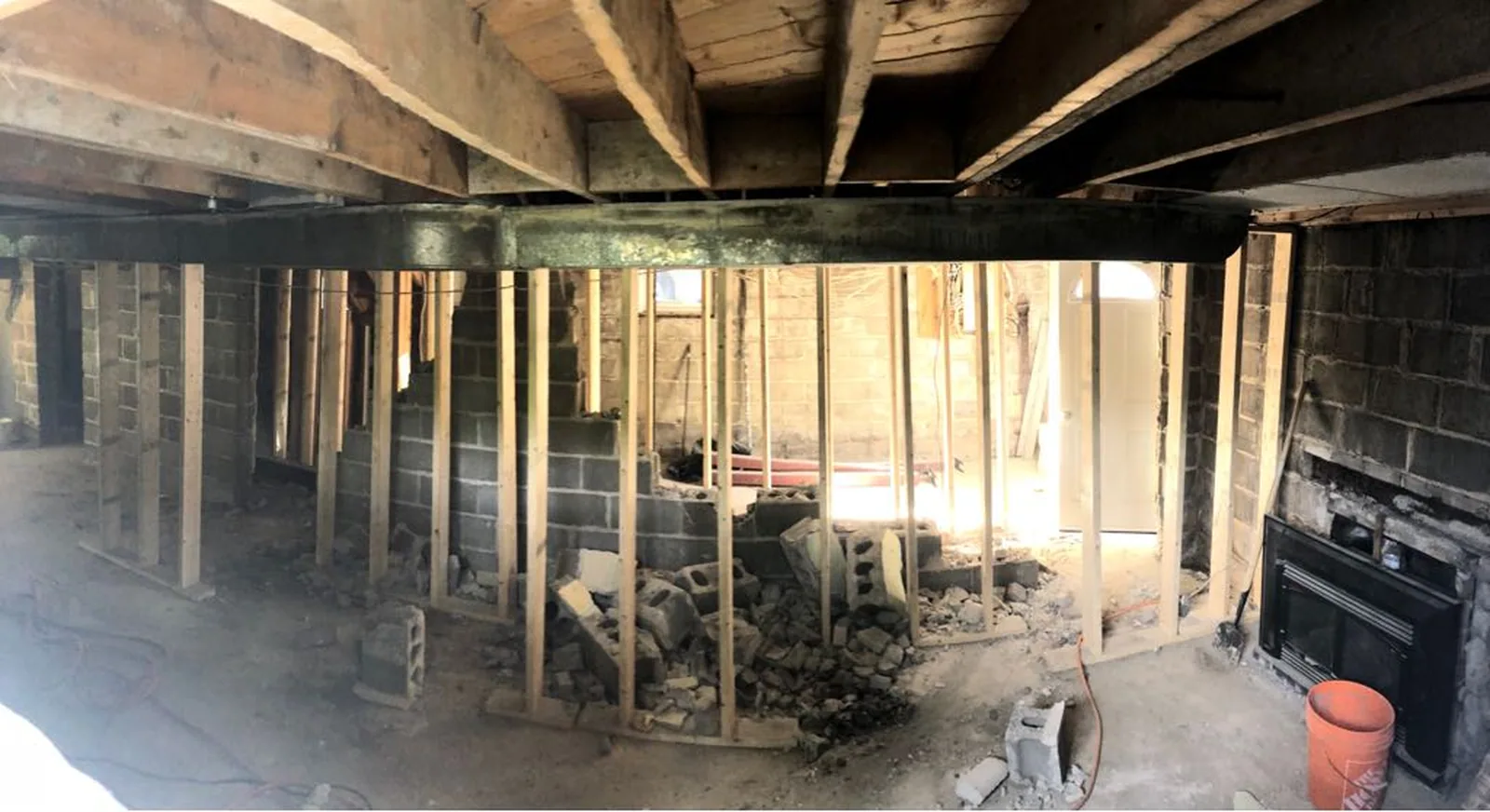 The masonry bearing wall demolished down the middle of the basement, the floor above held on shoring