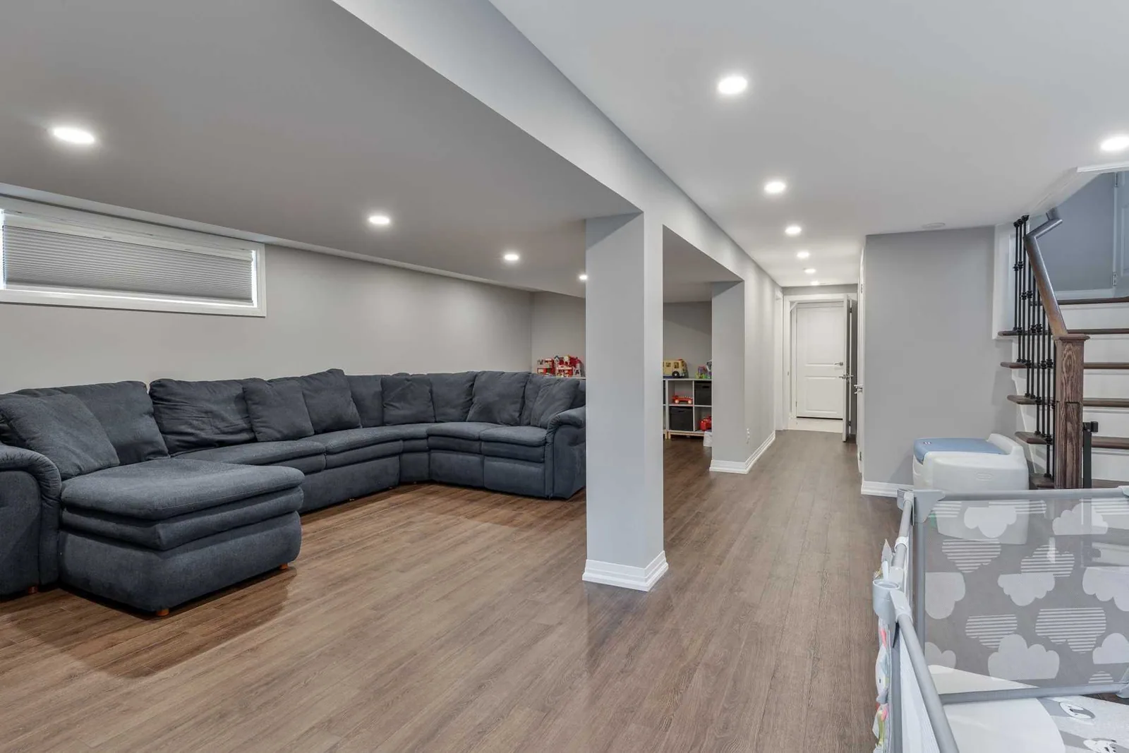 The finished Toronto basement after the load-bearing wall came out: one open room with no posts in the middle