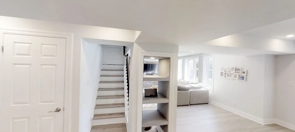 The staircase and the built-in shelving, in a finished basement in Oakville by Harmony Basements, captured in 360 degrees