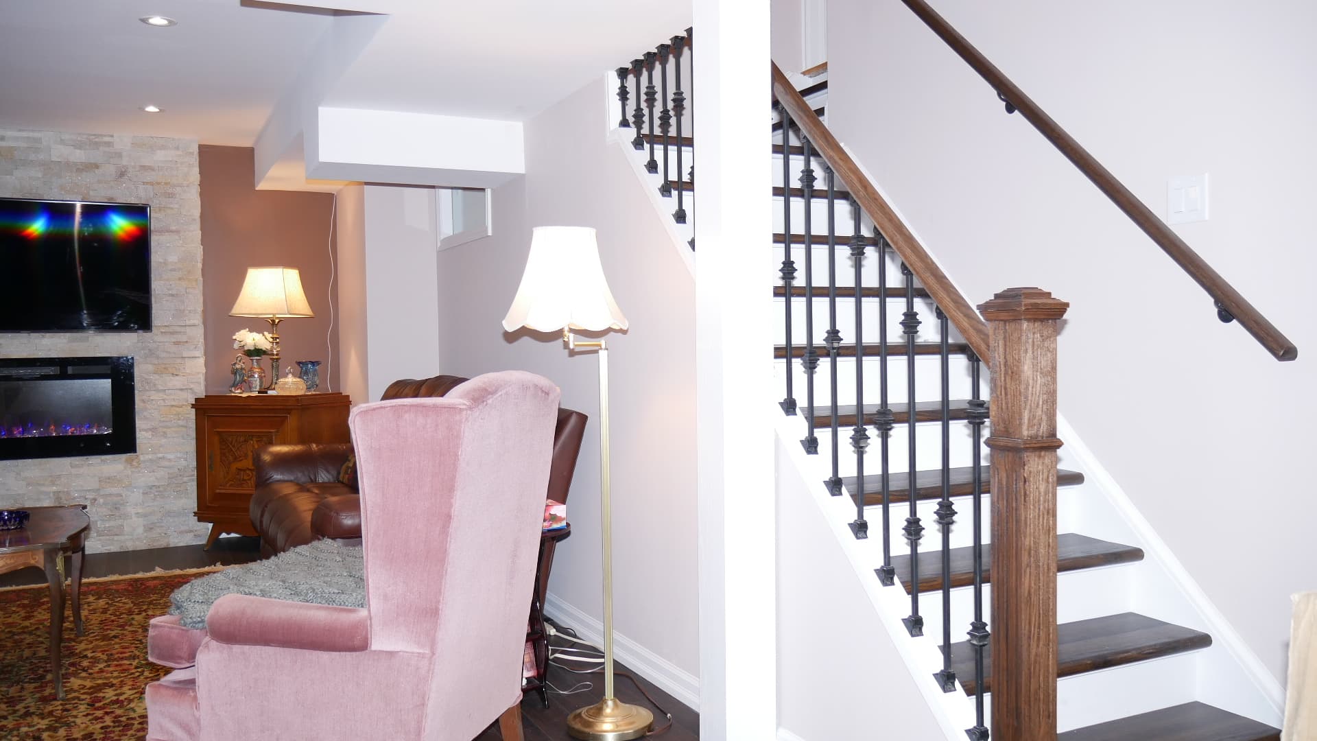The family room and the staircase in a finished basement by Harmony Basements