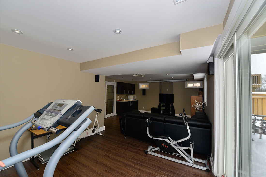The gym corner and the walkout doors in a finished basement by Harmony Basements