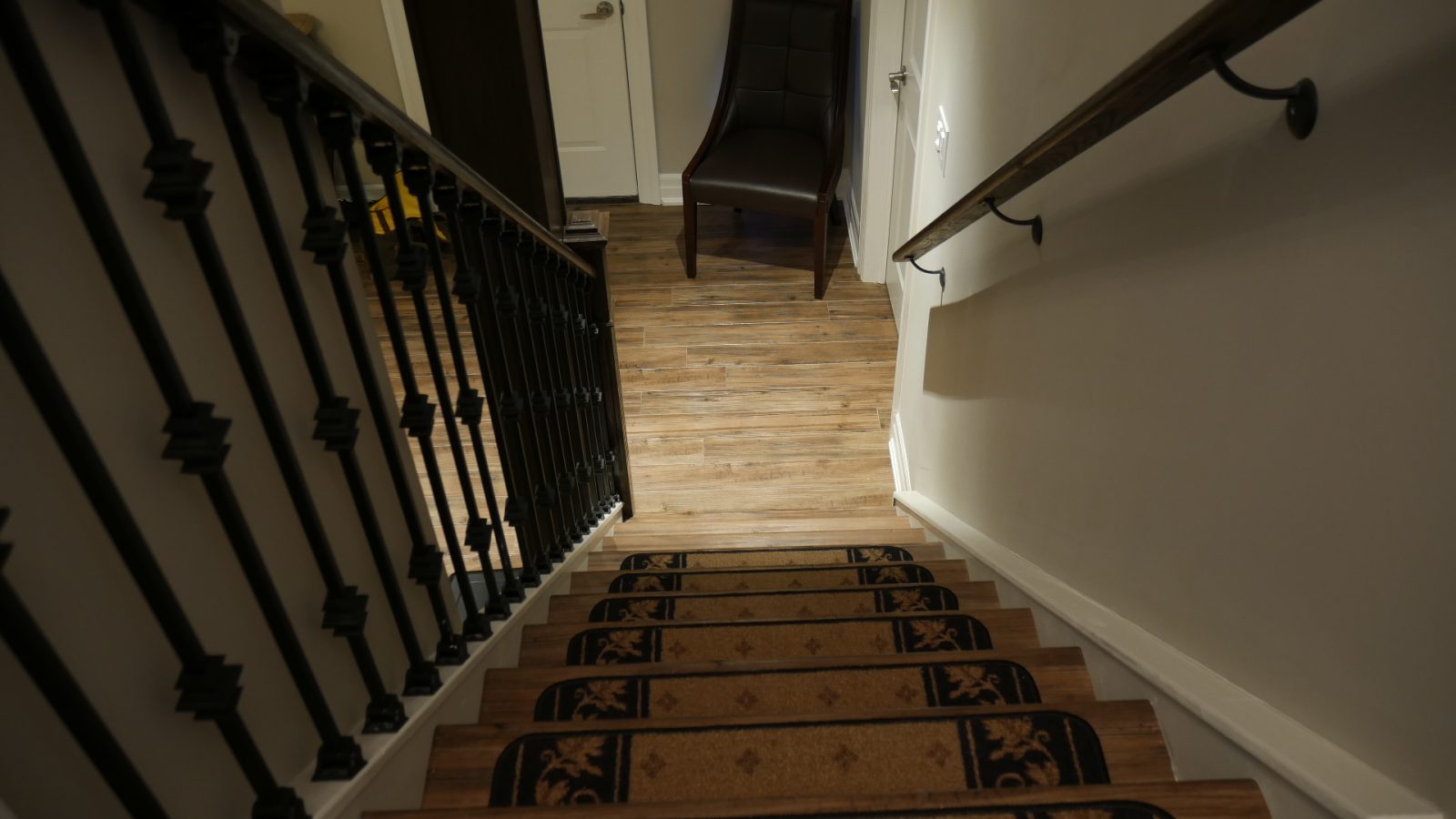 The staircase: iron pickets in a finished basement in King City by Harmony Basements