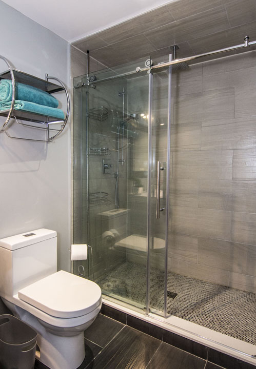 The bathroom: a glass shower in a finished basement in Maple by Harmony Basements