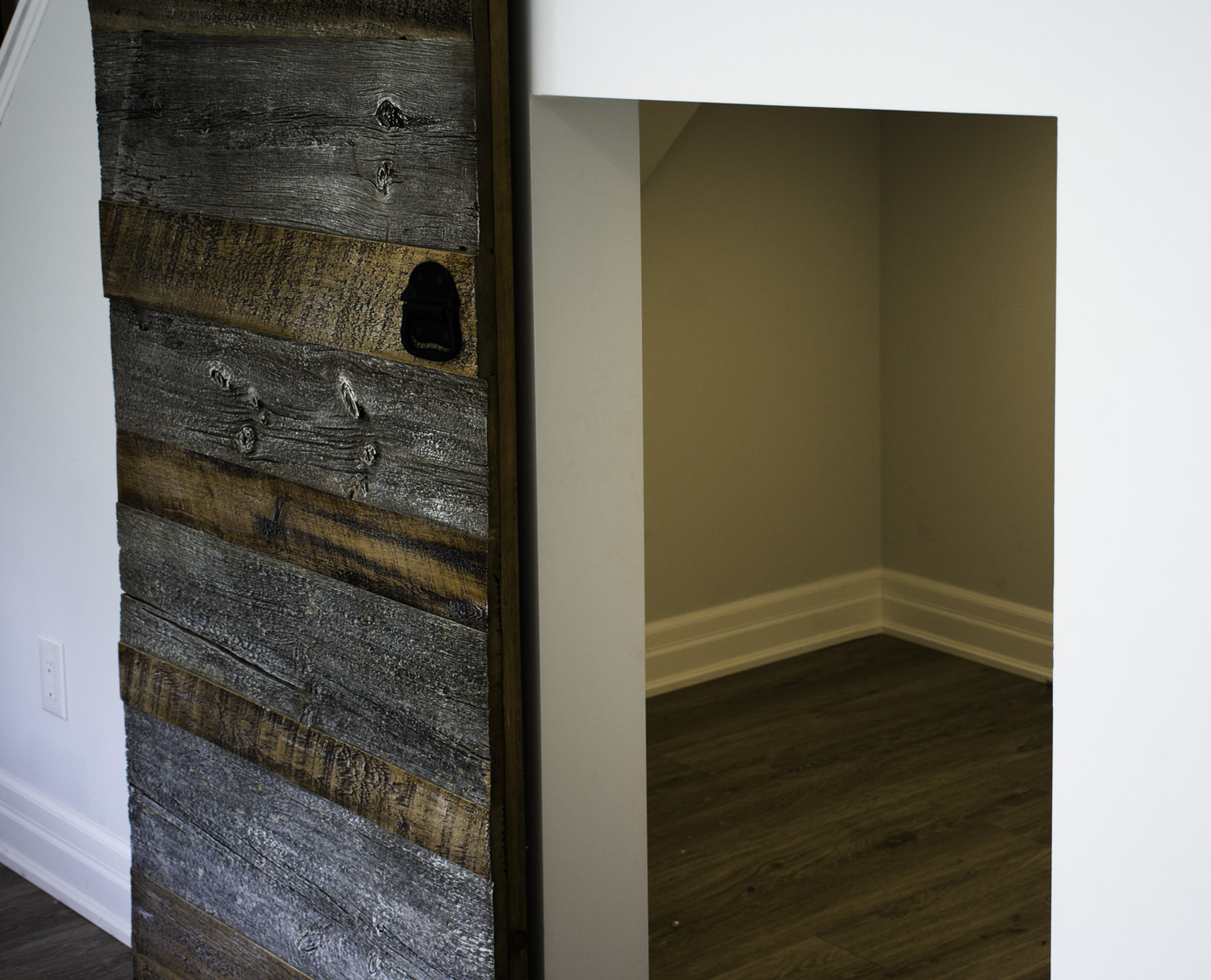 The storage room behind the barn door in a finished basement in Oakville by Harmony Basements