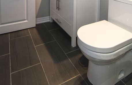 Finished basement washroom with a toilet and a white vanity