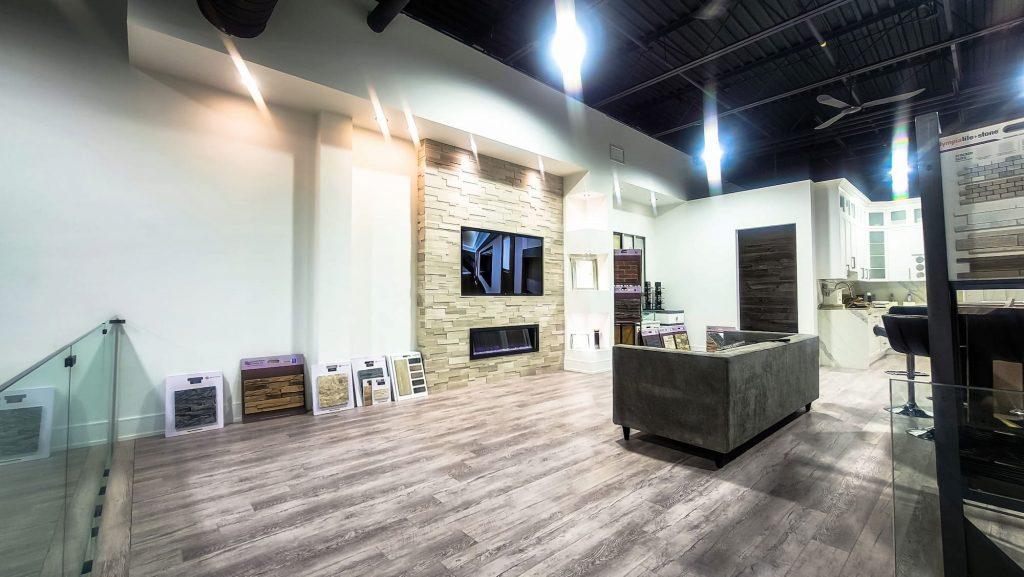 Open finished space with a stone fireplace wall and a glass railing