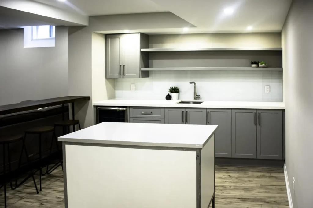 Grey basement kitchenette with open shelves and an island