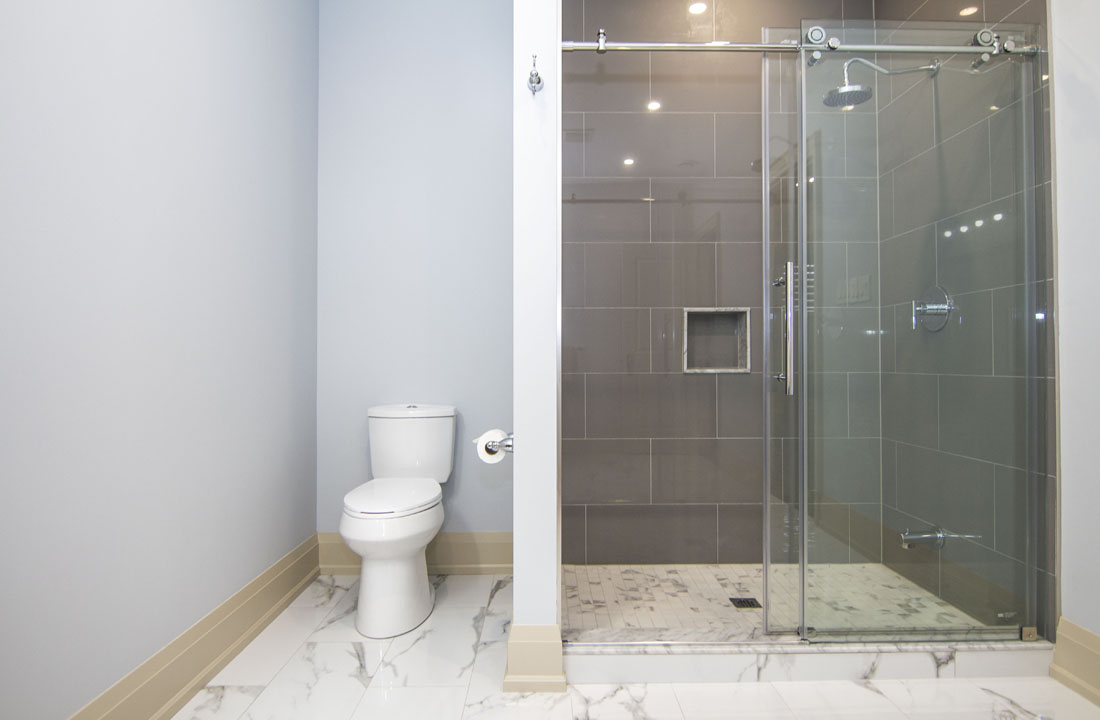 Basement bathroom in Woodbridge: a glass shower, by Harmony Basements