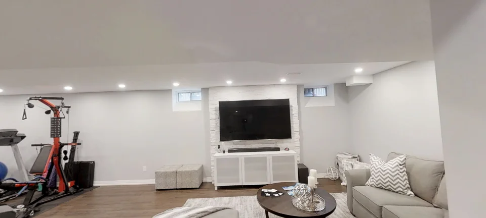 Basement family room in Stouffville: a stone TV wall and the gym corner, captured in 360 degrees &mdash; a finished basement by Harmony Basements