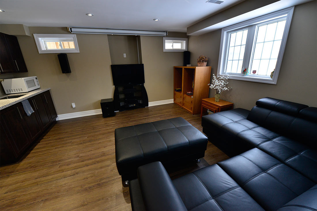 Basement mini kitchen in Brampton: a kitchenette, a family room and a TV wall &mdash; a walkout basement by Harmony Basements