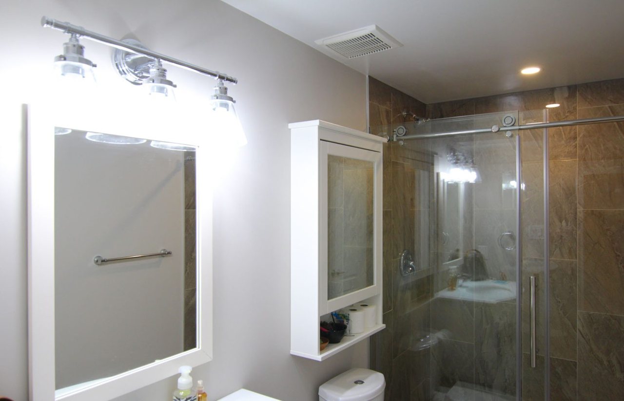 Basement walk-in shower in Burlington: glass doors and a tiled wall, by Harmony Basements